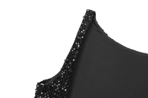 Détail macro de paillettes noires cousues sur l'ourlet d'une robe boule sans manches