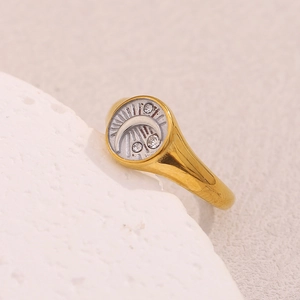 Macro detail of 18K gold plated celestial ring with embossed moon and star patterns
