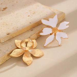Détail de bagues fleurs en métal doré et émail blanc avec texture de pétales fine