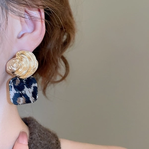 Close-up of vintage square leopard print earrings with gold spiral metal tops on ears