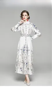 Détail de l'imprimé bohème sur robe blanche avec poignets boutonnés et ceinture assortie