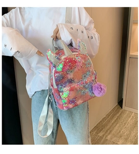 Detail of colorful sequin unicorn backpack featuring star patterns and purple fur pompom