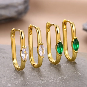 Detailed macro view of 18k gold plated rectangular earrings with white and green zircon stones