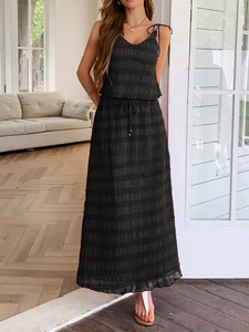 Two-piece black vacation set featuring a pleated camisole top and flowy maxi skirt