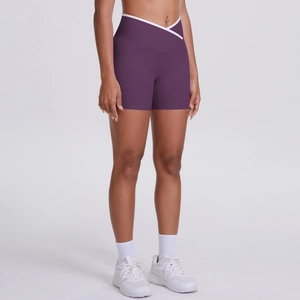 Détail de la taille croisée en V sur ce short de yoga violet taille haute à liseré blanc