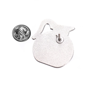 Detail of silver metal badge back showing textured surface and butterfly clutch fastener