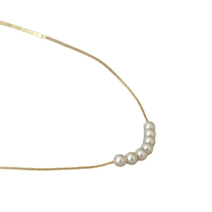 Minimalist gold plated brass necklace with six tiny white pearls on a fine chain