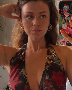 Close-up of golden spiral fan-shaped earrings on a model with vintage 18K gold design