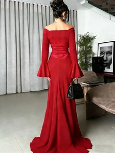 Rear view of a red off-shoulder evening gown featuring flared sleeves and pleated fishtail hem