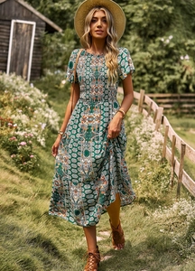 Détail de robe longue fleurie verte avec manches courtes et buste élastique smocké