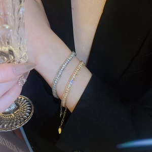 Close-up of gold and silver adjustable chain bracelets with sparkling pavé crystals