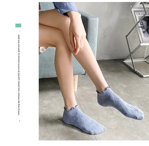 Detail of light blue low-cut cotton socks with heart jacquard and ruffle trim design