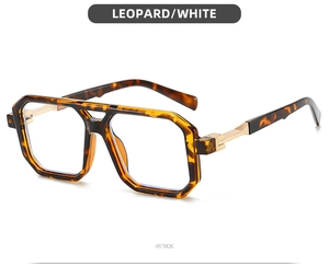 Macro side view of oversized leopard print eyewear featuring gold metal hinges and clear lenses