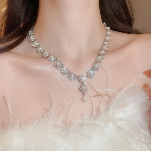 Elegant floral pearl tassel necklace with sparkling rhinestones worn on neck detail
