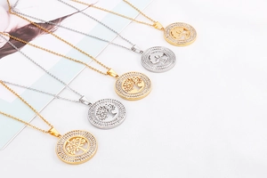 Close-up of tree of life pendants in gold and silver finish with sparkling crystals