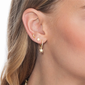 Detail of gold ear cuff set with lightning and star motifs inlaid with zircons