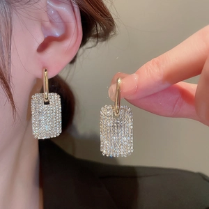 Vue détaillée de boucles d'oreilles géométriques dorées avec pavé de zircone étincelant