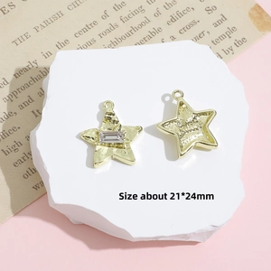 Detailed view of Y2K star-shaped gold charms with gemstone inlay and textured finish