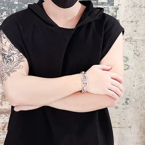 Close-up of industrial style men's stainless steel chunky D-ring chain bracelet on wrist