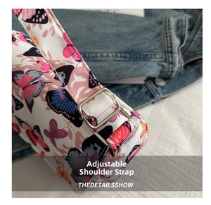 Detailed macro view of adjustable silver buckle and strap on butterfly print shoulder bag