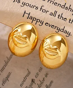 Detail van gouden roestvrijstalen ovale oorknopjes met een 3D-reliëf van lachende lippen