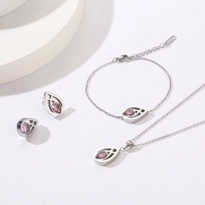 Detailed set of silver titanium teardrop jewelry with pink gemstones and hollow design