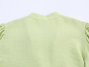Detail of light green blouse back with textured fabric and delicate pleated shoulder seams