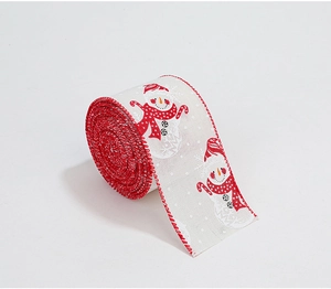 Detail of Christmas ribbon roll with snowman and candy cane prints on white linen