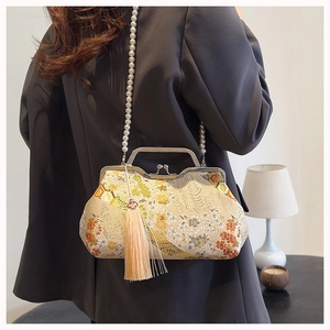 Detail of Chinese style shell bag featuring floral embroidery and elegant pearl chain