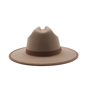 Close-up of a camel wool fedora hat featuring a brown ribbon band and fine brim edging