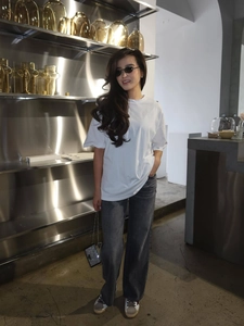 Minimalist white loose-fit cotton T-shirt styled with grey wide-leg denim and accessories