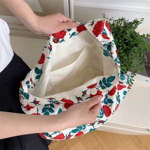 Detail view of the floral canvas tote bag featuring a zipper pocket and magnetic closure