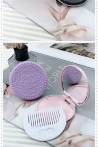Close-up of purple cookie-shaped mirror and white comb on stylish background