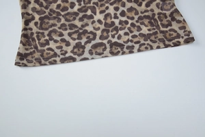 Macro shot of leopard print sheer mesh fabric hem showing delicate stitching details