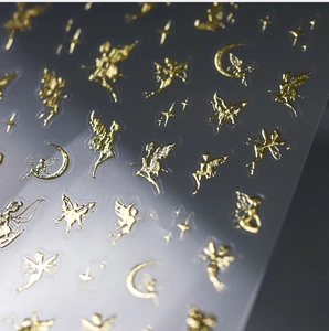 Detailed close-up of golden bronzing nail stickers with fairy, moon and star patterns