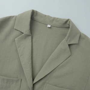 Macro detail of sage green cotton linen shirt collar with S size tag and pocket texture