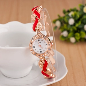 Close-up of rose gold quartz watch with red enamel leaf design and crystal bezel