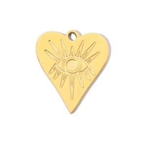 Macro detail of golden heart-shaped stainless steel pendant with evil eye engraving