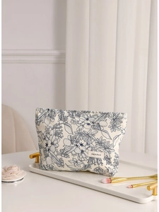 Floral canvas makeup bag with blue retro prints and top zipper in a white tray