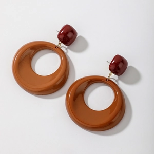Detailed view of bicolor acrylic hoop earrings featuring wine red square and amber ring