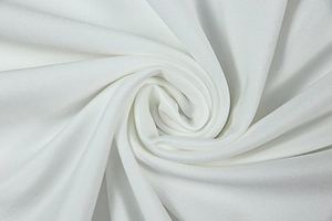 Detailed macro shot of premium white knit fabric showing fine diagonal texture and drape