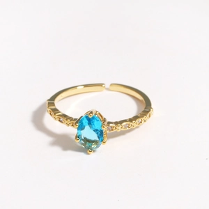 Elegant gold adjustable ring featuring an oval blue zircon and small white side stones