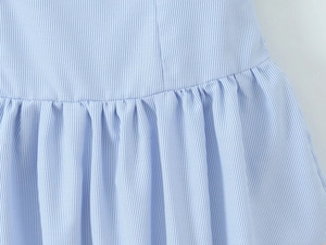 Detailed view of light blue and white striped fabric with fine pleated stitching texture