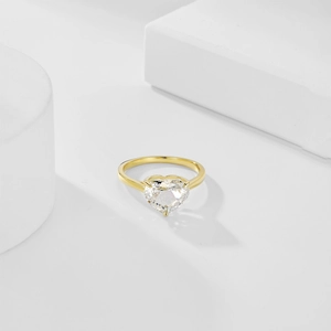 Detailed view of heart-cut clear gemstone ring with elegant gold-plated four-prong setting