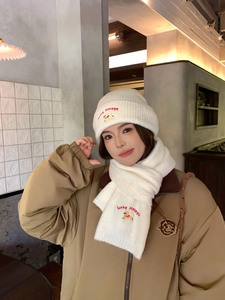 Detailed embroidery of lucky puppy on white knitted hat and scarf winter warm set