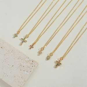 Gold cross necklaces and Hand of Fatima pendants with colorful zircon inlay on stone