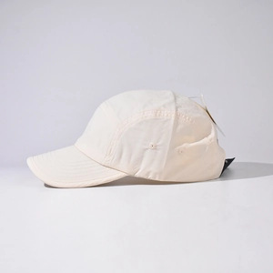 Detail view of the refined stitching and breathable eyelets on a minimal ivory camper hat