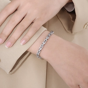 Detailed view of silver Byzantine titanium steel bracelet with lobster clasp on wrist
