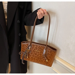 Gros plan détaillé sur l'imprimé léopard et le charme tressé du sac cabas chic