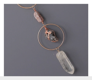 Detail of hand-wrapped copper wire jewelry with natural amethyst and raw crystals